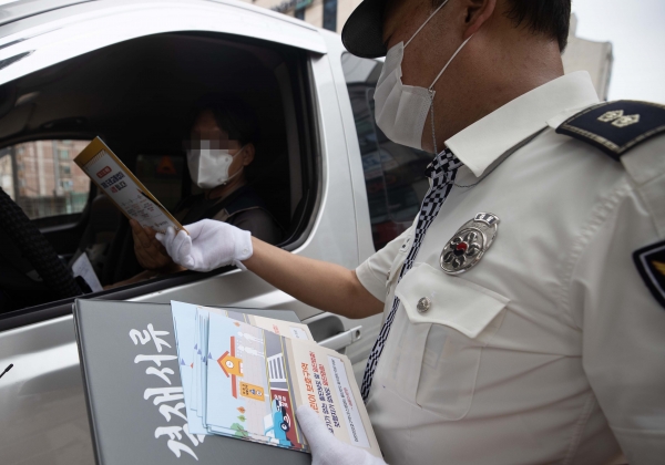 경찰이 운전자에게 새 도로교통법 시행 홍보물을 나눠주고 있다. (사진=뉴스핌)